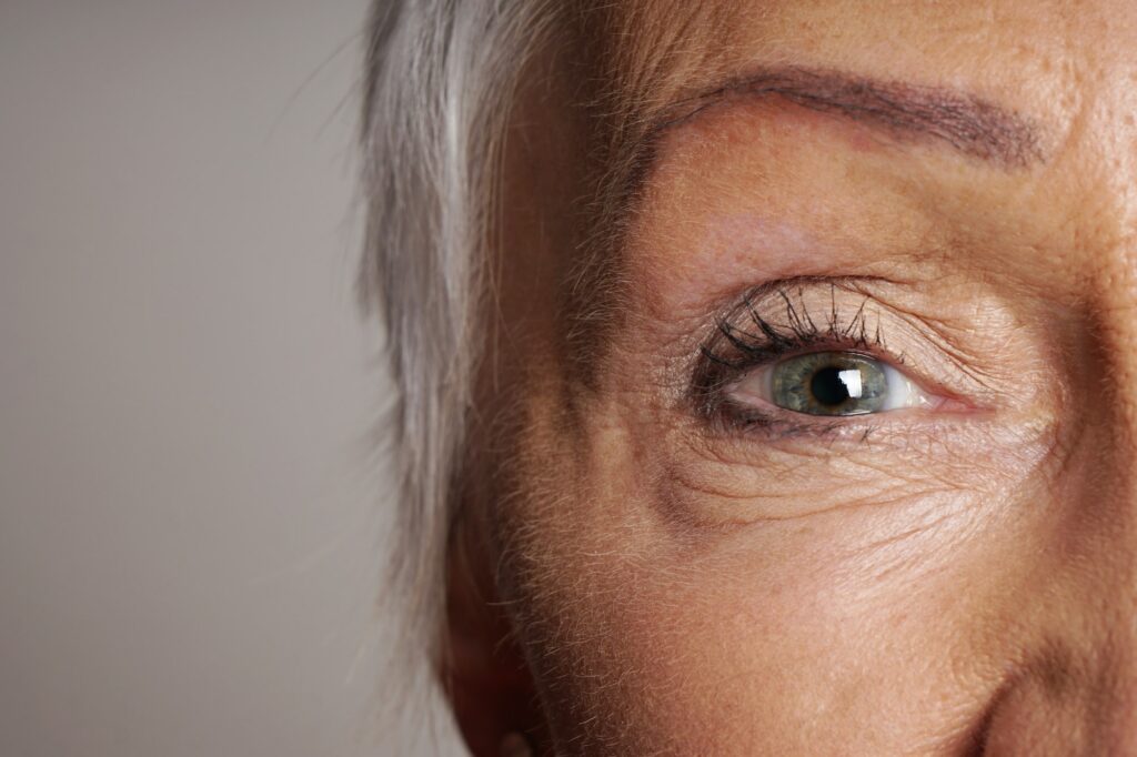 close-up detail of old woman with wrinkles around her green eyes